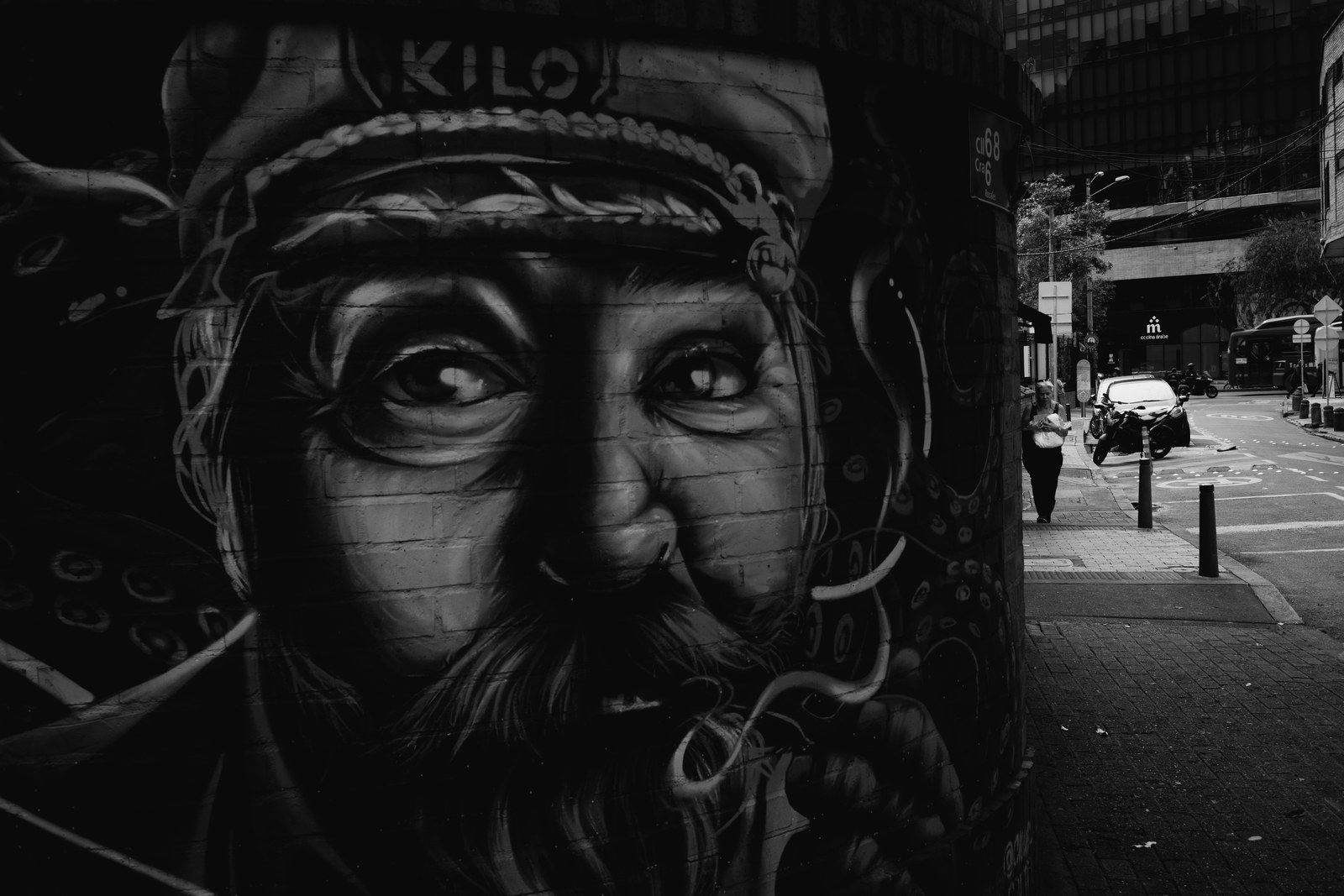 A painted face on a wall beside a Bogota street.